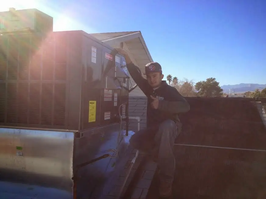 HVAC technician performing AC Tune-Up on a rooftop unit in Bella Vista